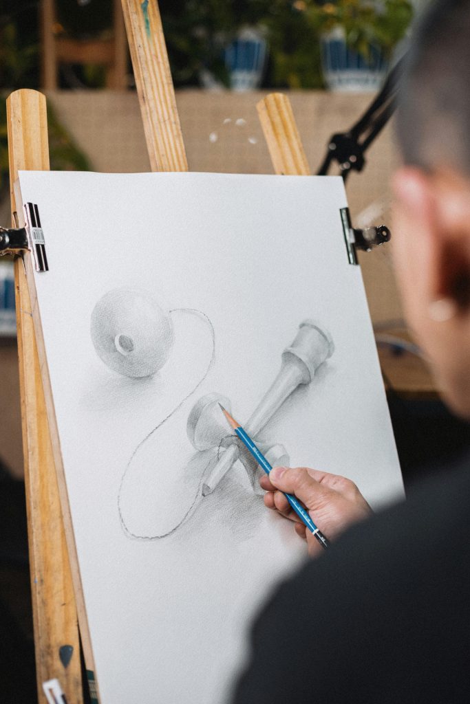 pexels-photo-31621700-31621700 Artist sketching kendama toy on easel. Shinjuku, Tokyo, Japan. Creative process.